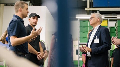 Der Hessische Wirtschaftsminister Tarek Al-Wazir im Gespräch mit zwei Männern