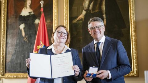 Ministerpräsident Boris Rhein überreicht Annette Ruske-Wolf das Verdienstkreuz am Bande.