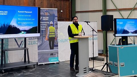 Ein Mann steht in einer Halle an einem Redepult