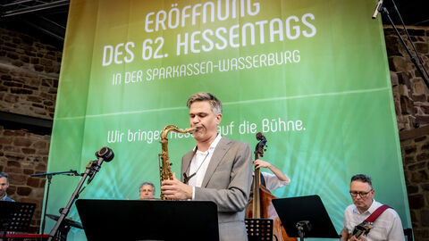 Eine Band spielt vor einem bunten Hintergrund