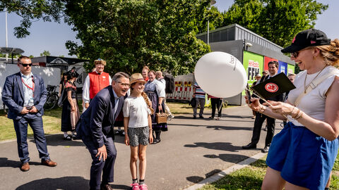 Ministerpräsident Boris Rhein macht ein Foto mit einem Kind.