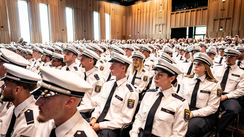 Mehrere Menschen in Uniform sitzen in einer Reihe.