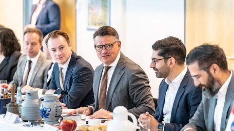 Ministerpräsident Boris Rhein, Wirtschaftsminister Mansoori und Chef der Staatskanzlei Benedikt Kuhn auf der Kabinettssitzung Drei Männer sitzen am Tisch und sprechen miteinander.
