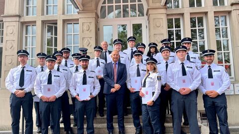 Justizminister Prof. Dr. Roman Poseck, Leiter des H. B. Wagnitz-Seminars Thomas Puffert und die Prüfungsabsolventinnen und Prüfungsabsolventen des allgemeinen Justizvollzugs