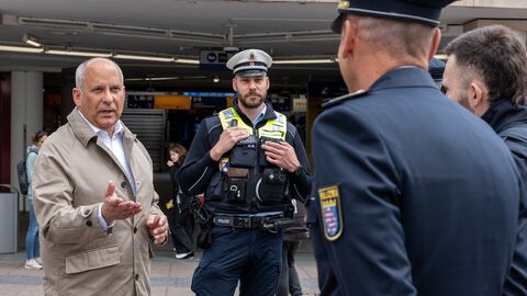 Innenminister Poseck steht mit Polizeibeamten in einer Innenstadt.
