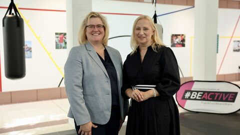 Sportministerin Stolz und LSBH-Präsidentin Kuhlmann stehen nebeneinander in einer Sporthalle.